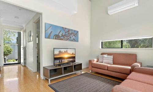 a living room with a couch and a flat screen tv at La Casita Preston Beach in Preston Beach