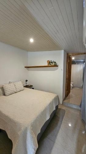 a bedroom with a bed and a shelf on the wall at KAIA VILLAGE, Santa Teresa, Costa Rica in Santa Teresa Beach