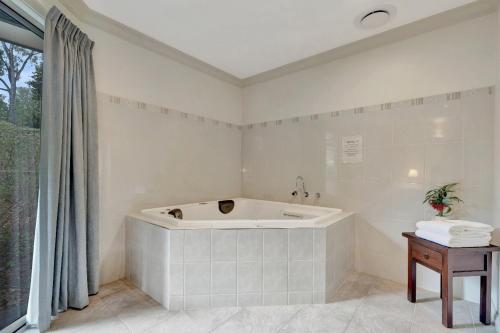 a white bath tub in a bathroom with a window at Emerald Creek Cottages in Emerald