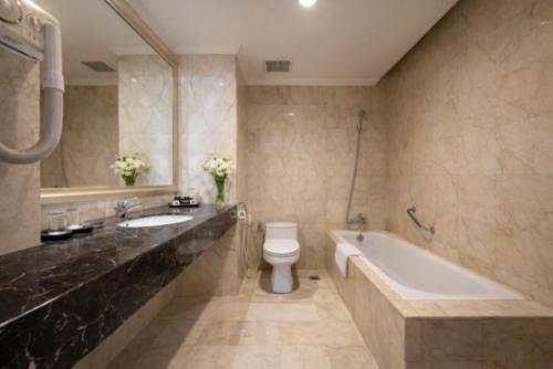 ein Badezimmer mit Badewanne, Toilette und Waschbecken in der Unterkunft The Mirah Hotel Bogor in Bogor