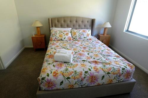 a bedroom with a bed with a flower comforter at Modern Private Townhouse Close to City & Transport in Perth
