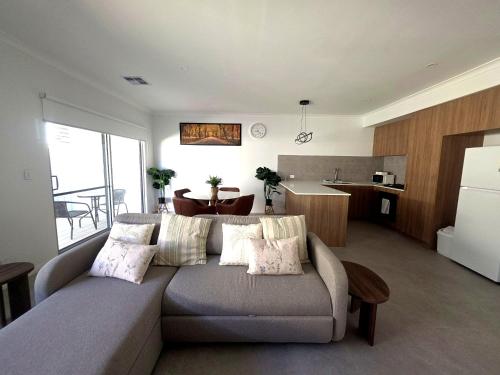a living room with a couch and a kitchen at Modern Private Townhouse Close to City & Transport in Perth