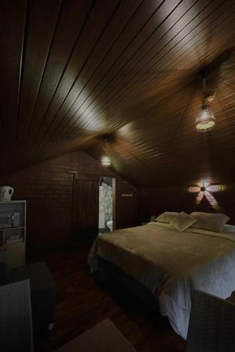 a bedroom with a large bed with a wooden ceiling at Cabaña en Chachimbiro in Hacienda San Francisco