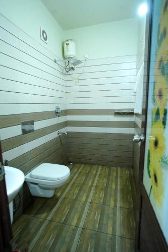 a bathroom with a toilet and a sink at Ayurnest Pool Resort Wayanad in Batheri