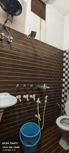 a bathroom with a toilet and a blue bucket at Sita pathik niwas in Jāmb