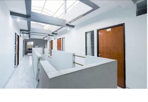 an office with white desks and a wooden door at Hotel Cemara Gading in Bubulak 3