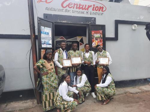 eine Gruppe von Menschen posiert für ein Foto vor einem Gebäude in der Unterkunft Le Centurion in Brazzaville