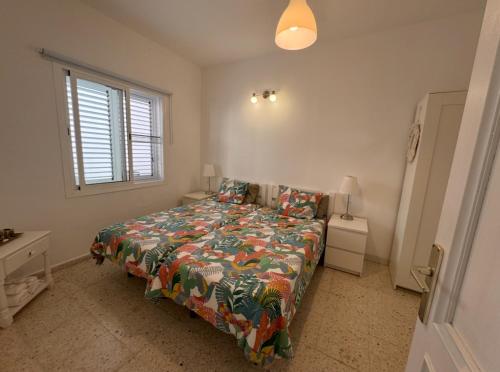 a bedroom with a bed with a colorful comforter and a window at Vidamar in Abades