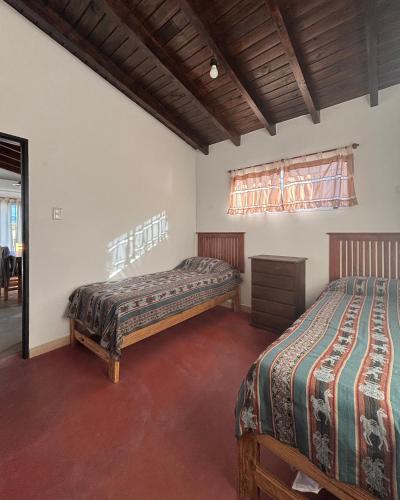 a bedroom with two beds and a window at Cabañas Pukara in Cafayate
