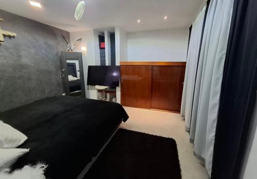 a bedroom with a black bed and a desk at suites vergel terraza in Orizaba