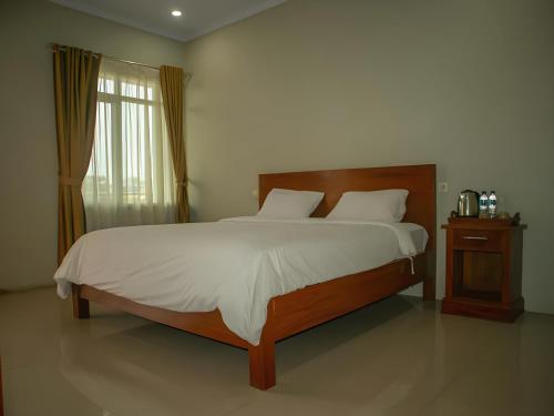 een slaapkamer met een groot bed en een raam bij Hotel Inayah Syariah in Kumprung