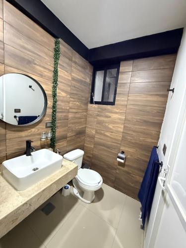 a bathroom with a toilet and a sink and a mirror at Hermoso Departamento Moderno con alberca in Boca del Río
