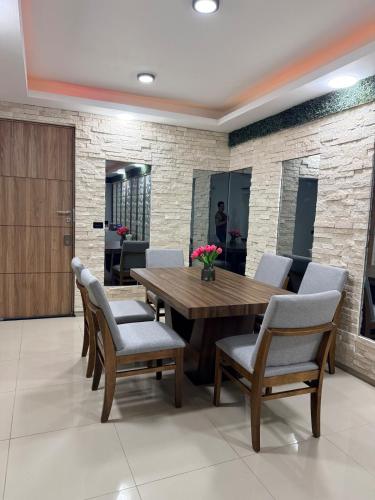 a dining room with a wooden table and chairs at Hermoso Departamento Moderno con alberca in Boca del Río