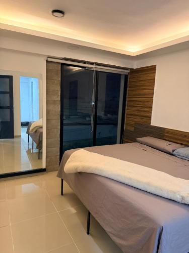 a bedroom with a large bed and a mirror at Hermoso Departamento Moderno con alberca in Boca del Río