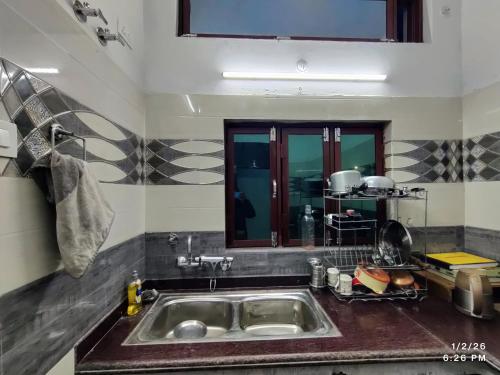 a kitchen with a sink and a counter top at MK Devbhoomi Homestay in Kandikhal