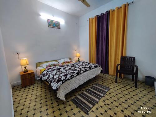 a bedroom with a bed and a chair and curtains at MK Devbhoomi Homestay in Kandikhal