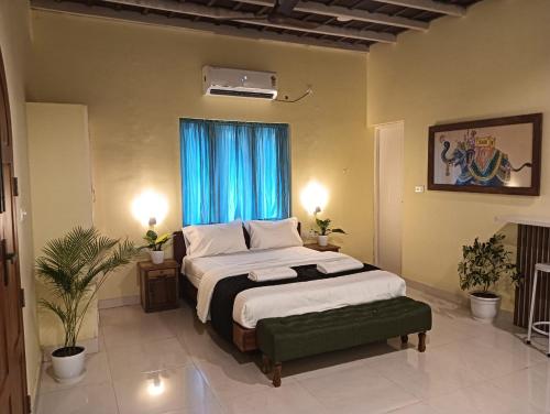 een slaapkamer met een groot bed en een blauw raam bij Om Villa in Varkala