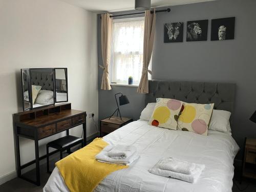 a bedroom with a bed and a desk and a mirror at Lancing Apartments - Spacious 2 Bed - Sleeps 6 - Burnham Village in Slough