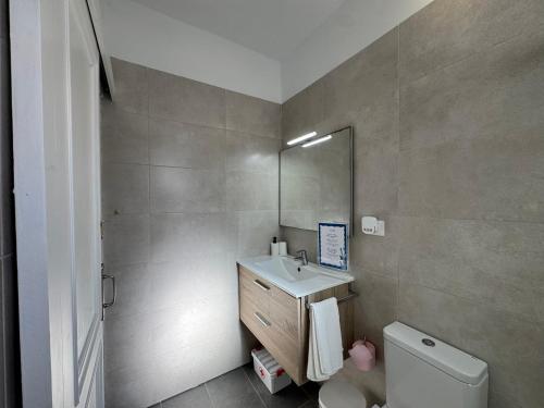 a bathroom with a sink and a toilet and a mirror at Vidamar in Abades