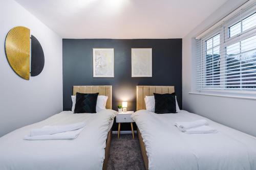 two beds sitting next to each other in a room at 2 BDR House By Eason Stays Short Lets Stockport in Stockport