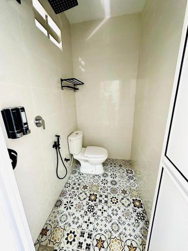 a bathroom with a toilet and a tiled floor at Homestay Babah - Private Chalet in Malacca
