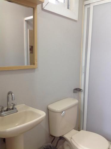 a bathroom with a toilet and a sink and a mirror at Hotel Galeria & Boutique in Mexico City