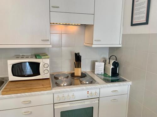 Una pequeña cocina con microondas y estufa. en Casa Rosa, en Rovio