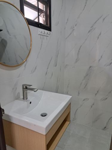 a white bathroom with a sink and a mirror at Bancha white house in Ban Bo Han