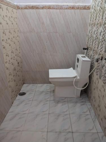 a small bathroom with a toilet in a shower at Magic of magh snan in Prayagraj
