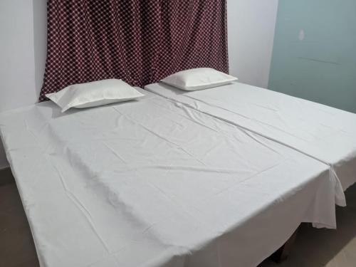 a white bed with two white pillows on it at Magic of magh snan in Prayagraj