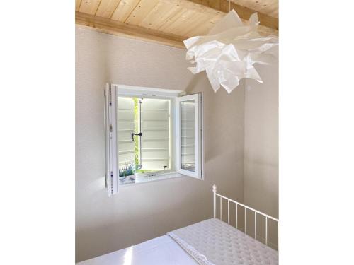 a room with a window and a chandelier at Private Hideaway in ut Island in Otočić Svršata Mala