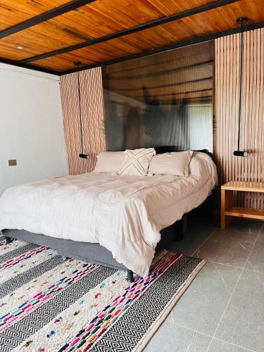 a bedroom with a large bed with a wooden ceiling at La Boca del Lagarto Lodge in Cucunubá