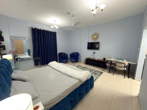 a living room with a bed and a dining room at spacious fully furnished studio apartment in Emirates cluster in Dubai