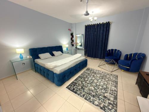 a bedroom with a blue bed and a blue couch at spacious fully furnished studio apartment in Emirates cluster in Dubai