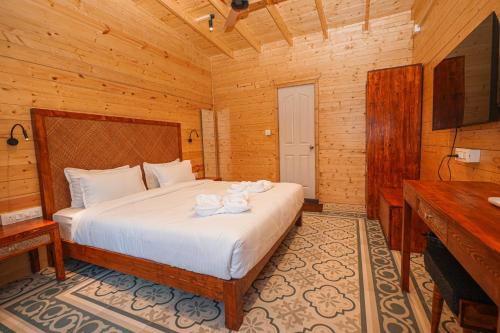 a bedroom with a bed in a wooden room at Oyster Bay Beach Resort in Anjuna