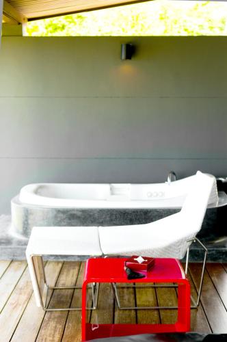 a bathroom with a red table and a bath tub at The Houben - Adult Only in Ko Lanta