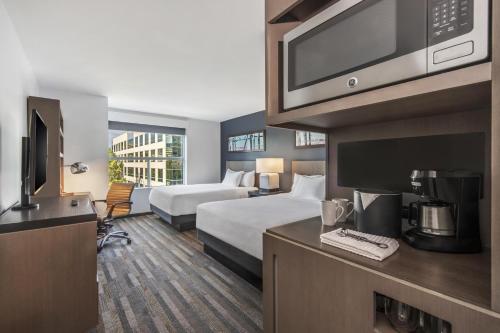 ein Hotelzimmer mit zwei Betten und einem Fernseher in der Unterkunft Hyatt House Irvine/John Wayne Airport in Irvine