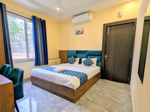 a bedroom with a bed with blue pillows at Ganga Yamuna View in Prayagraj