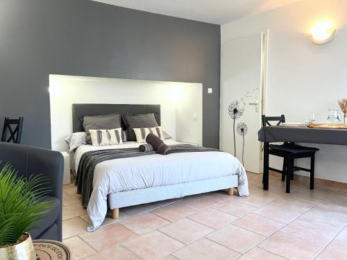 a bedroom with a bed and a table and a piano at Le Petit Cocon - Lumineux & Confortable in Cerizay