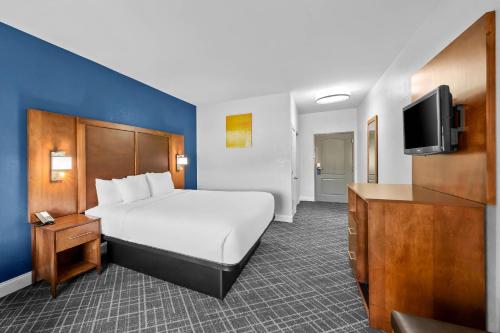 a hotel room with a bed and a flat screen tv at Comfort Inn & Suites Plainville-Foxboro in Plainville