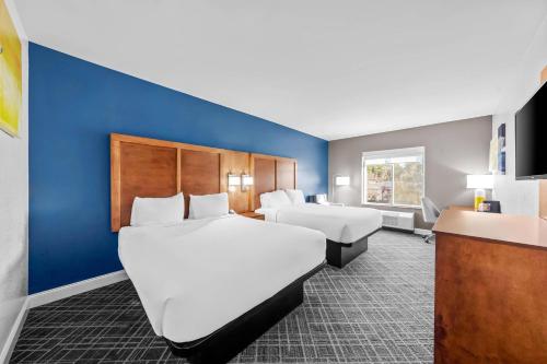 a hotel room with two beds and a blue wall at Comfort Inn & Suites Plainville-Foxboro in Plainville