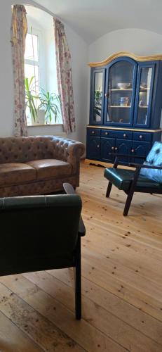 een woonkamer met een bank en een blauw dressoir bij Gwuni's Farm in Geithain