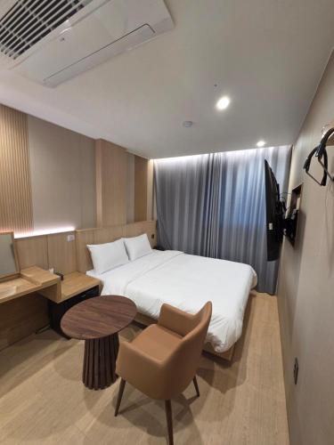 a bedroom with a bed and a desk and a chair at Golden Hotel 골든 호텔 in Hyomoktong-Ilgu