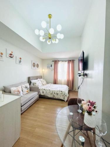 a living room with a couch and a bed and a table at 12F Condo at The Loop Tower Limketkai Center CDO in Cagayan de Oro