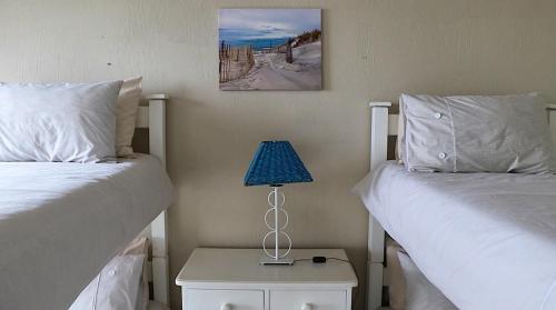a bedroom with two beds and a lamp on a night stand at Waves End Holiday Home in Southbroom