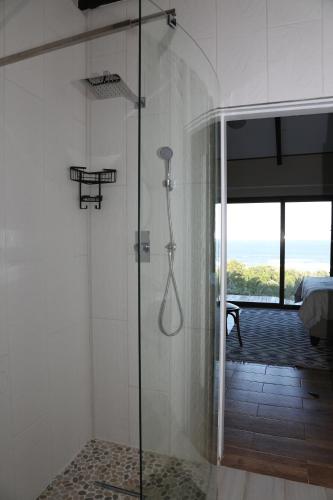 a shower with a glass door in a bathroom at Waves End Holiday Home in Southbroom