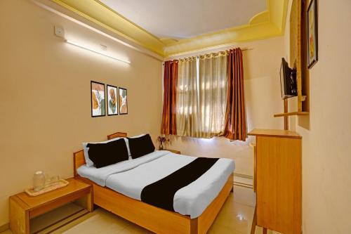 a hotel room with a bed and a window at Collection O Dandiya Bazar Formerly Vrundavan Residency in Vadodara