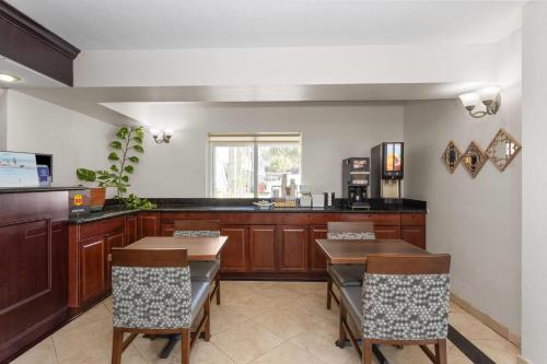 a kitchen with wooden cabinets and a table and chairs at Super 8 Motel by Wyndham near Fort Lauderdale Arpt in Dania Beach