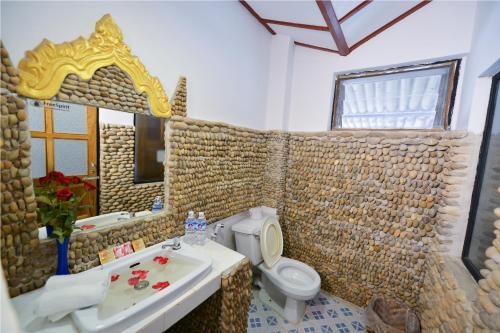 a bathroom with a sink and a toilet and a mirror at Teak Wood Hotel in Nyaungshwe Township