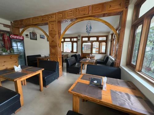 un soggiorno con tavolo e sedie e una sala da pranzo di Hotel Purnima by smugglers hotels a Kasol